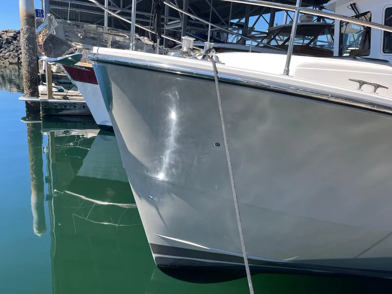 Slide: The Image of 2025 Helmsman Trawlers 43E PILOTHOUSE docked, reflecting on calm water. - 24