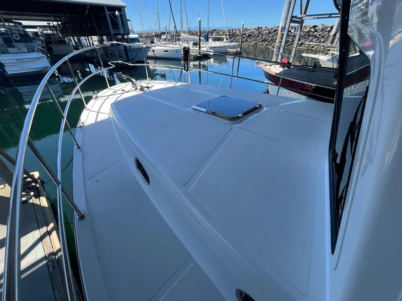 Slide: The Image of 2025 Helmsman Trawlers 43E PILOTHOUSE docked, showcasing sleek deck design and marina view. - 25