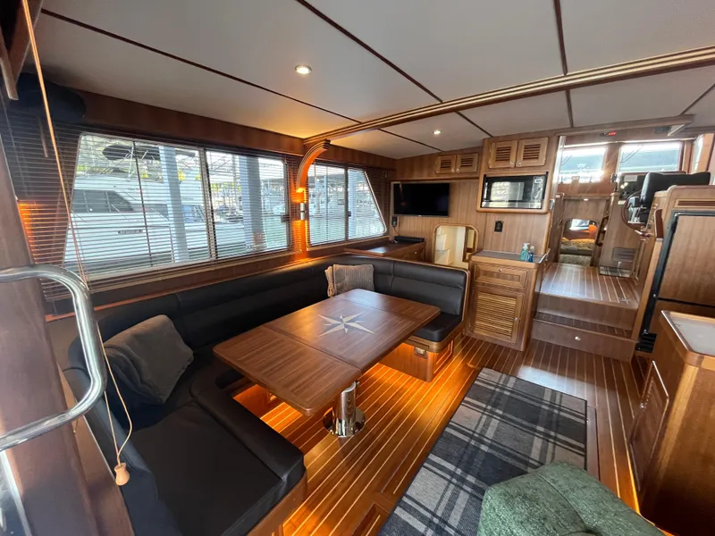 Slide: The Image of Luxurious interior of 2025 Helmsman Trawlers 43E Pilothouse with wood finishes and cozy seating. - 3