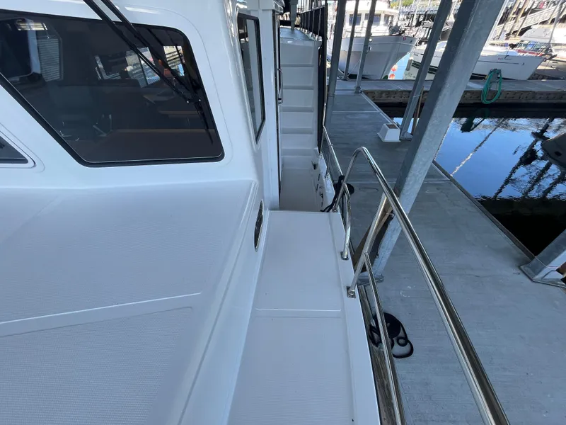 Slide: The Image of 2025 Helmsman Trawlers 43E PILOTHOUSE docked, showcasing sleek design and spacious deck. - 30