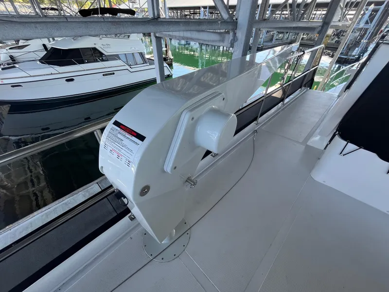 Slide: The Image of 2025 Helmsman Trawlers 43E Pilothouse deck with winch, docked near another boat. - 33