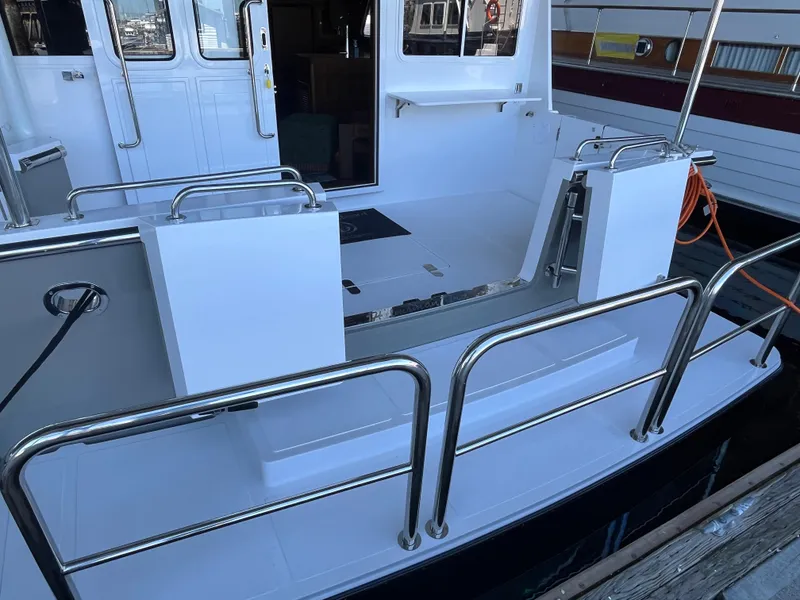 Slide: The Image of Helmsman Trawlers 43E Pilothouse 2025, rear deck view with stainless steel railings. - 39