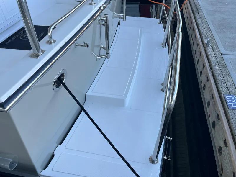 Slide: The Image of Helmsman Trawlers 43E Pilothouse 2025 docked, featuring sleek stainless steel railings. - 40