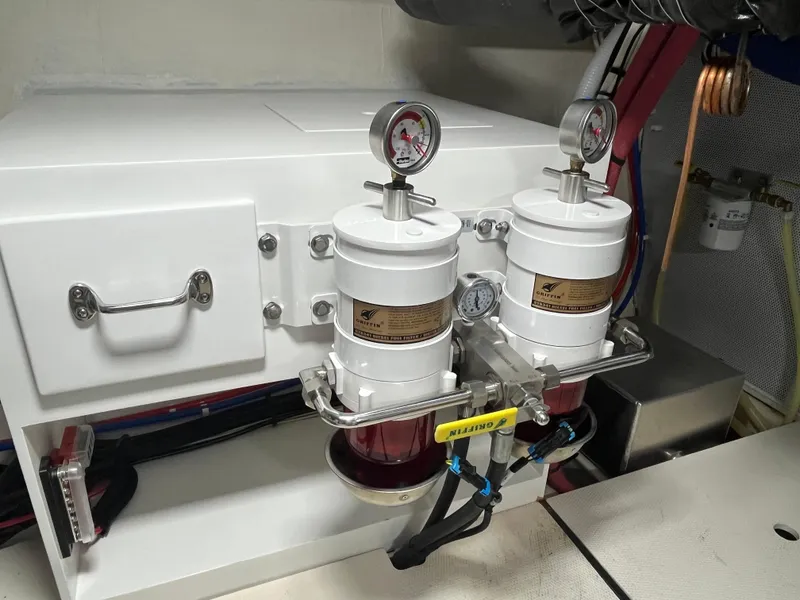 Slide: The Image of Engine room of 2025 Helmsman Trawlers 43E PILOTHOUSE with dual fuel filters and gauges. - 46