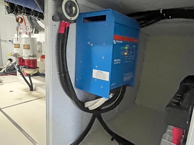Slide: The Image of Electrical system inside 2025 Helmsman Trawlers 43E Pilothouse, featuring blue inverter and wiring. - 47
