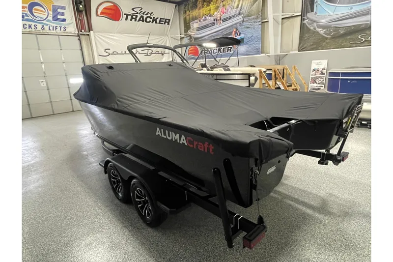 Slide: The Image of 2026 Alumacraft Competitor 195X Sport boat covered in a showroom. - 18