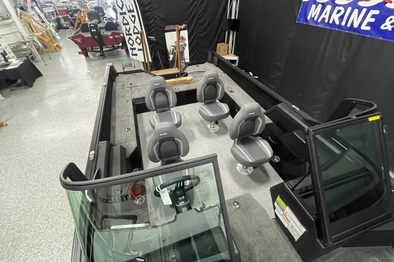 Slide: The Image of 2026 Alumacraft Competitor 195X Sport boat interior with four seats and steering console. - 6