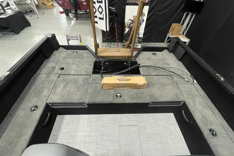 Slide: The Image of 2026 Alumacraft Competitor 195X Sport boat interior with gray carpeted deck. - 7