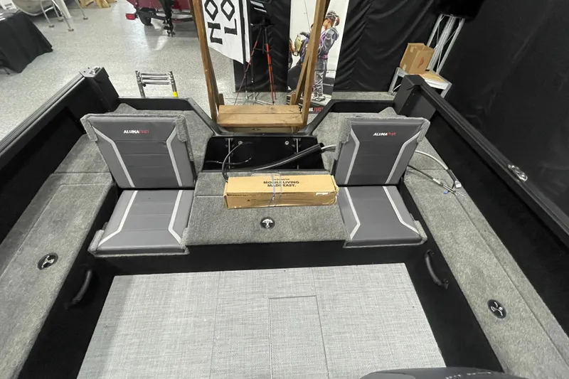 Slide: The Image of 2026 Alumacraft Competitor 195X Sport interior with gray seating and storage compartments. - 8