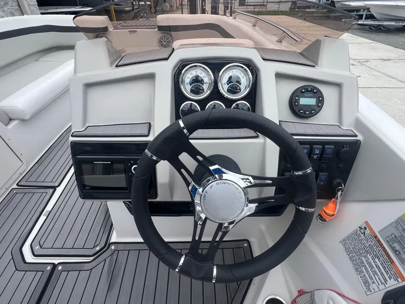 Slide: The Image of 2022 Starcraft SVX 191 OB boat dashboard with steering wheel and control panel. - 7