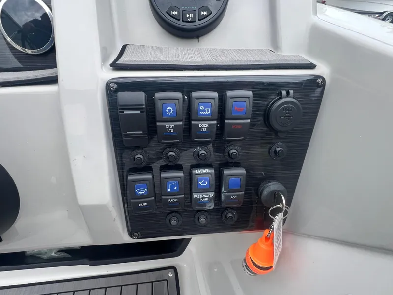 Slide: The Image of Control panel of 2022 Starcraft SVX 191 OB boat with various switches and key ignition. - 8
