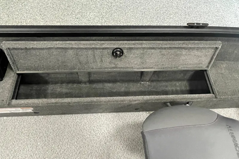 Slide: The Image of 2026 Alumacraft Voyageur 175 Tiller boat storage compartment with gray interior and seat. - 12