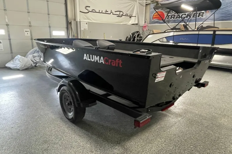 Slide: The Image of 2026 Alumacraft Voyageur 175 Tiller boat in showroom, black exterior, on trailer. - 3