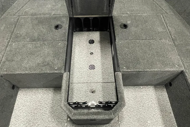 Slide: The Image of Interior of 2026 Alumacraft Voyageur 175 Tiller boat, featuring carpeted storage compartments. - 6