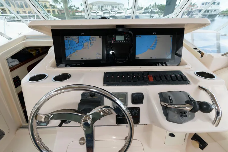 Slide: The Image of 2007 Grady-White Express 360 helm with dual navigation screens and steering wheel. - 13