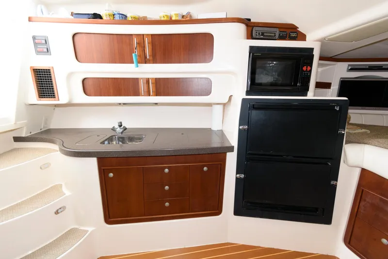 Slide: The Image of 2007 Grady-White Express 360 interior kitchen with sink, microwave, and storage cabinets. - 22