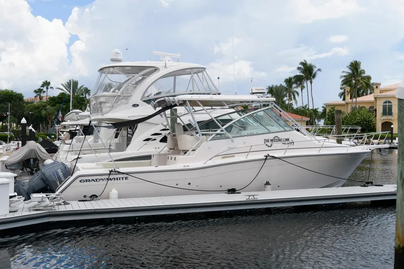 Slide: The Image of 2007 Grady-White Express 360 boat docked in a marina, surrounded by palm trees. - 4