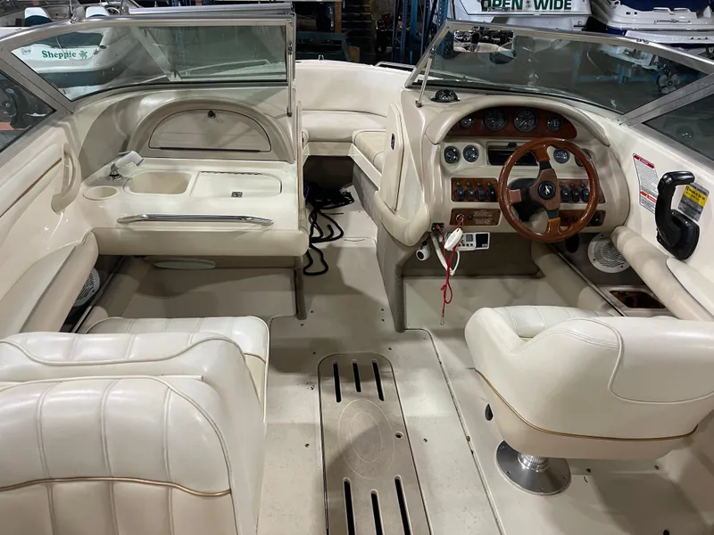 Slide: The Image of Interior of a 1995 Sea Ray Signature Select boat with white leather seating and wooden steering wheel. - 11