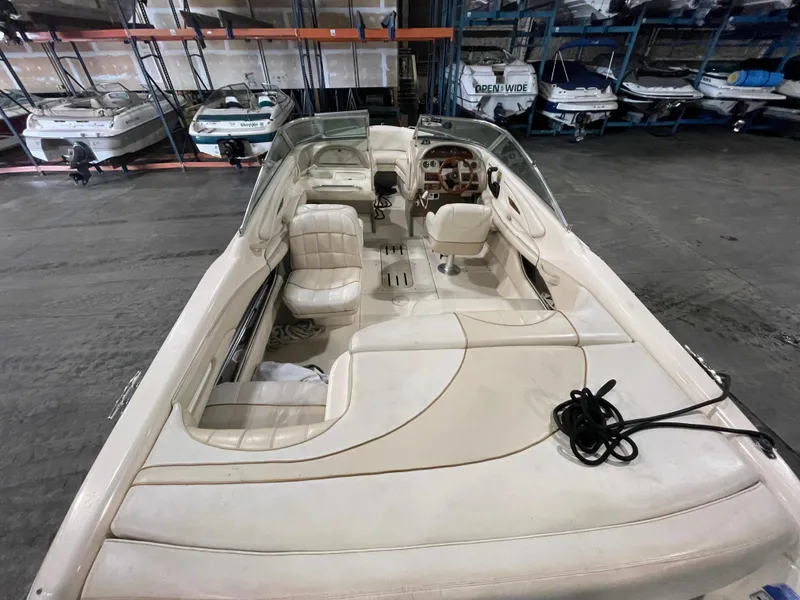 Slide: The Image of 1995 Sea Ray Signature Select boat interior in storage, featuring white seating and dashboard. - 3