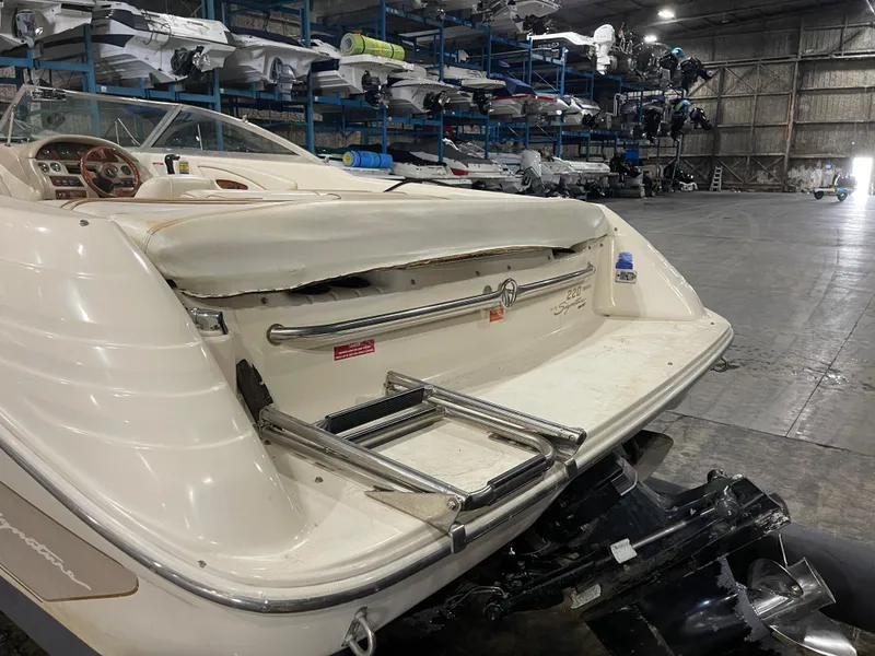 Slide: The Image of 1995 Sea Ray Signature Select boat in storage, showcasing rear deck and ladder. - 6