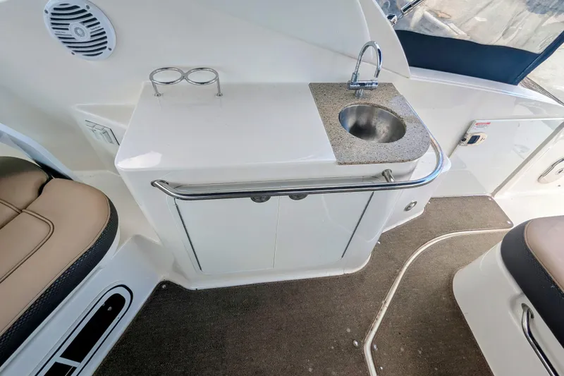Slide: The Image of 2017 Sea Ray Sundancer 280 interior with sink, countertop, and seating area. - 15