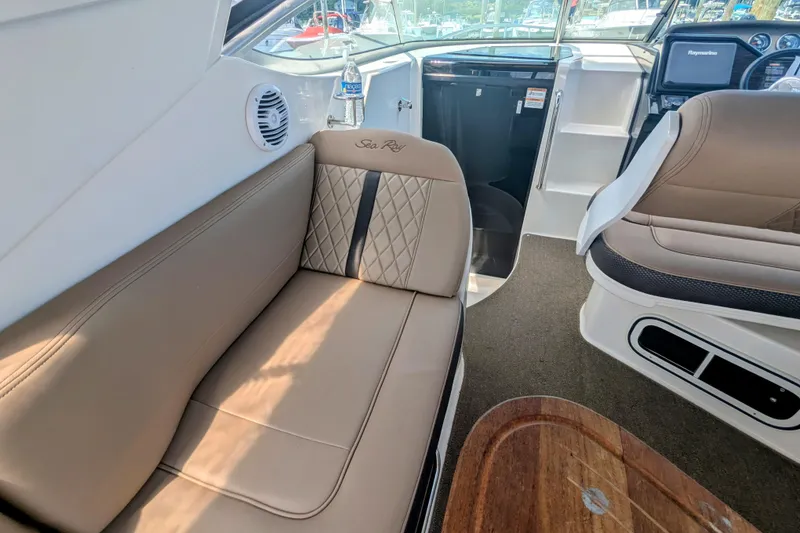 Slide: The Image of Interior of 2017 Sea Ray Sundancer 280, featuring beige seating and modern dashboard. - 18