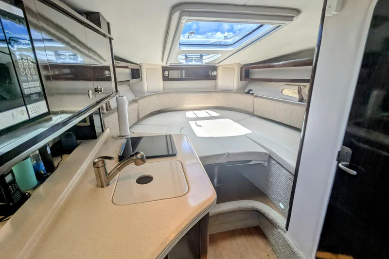 Slide: The Image of Interior of 2017 Sea Ray Sundancer 280, featuring a cozy seating area and kitchenette. - 21