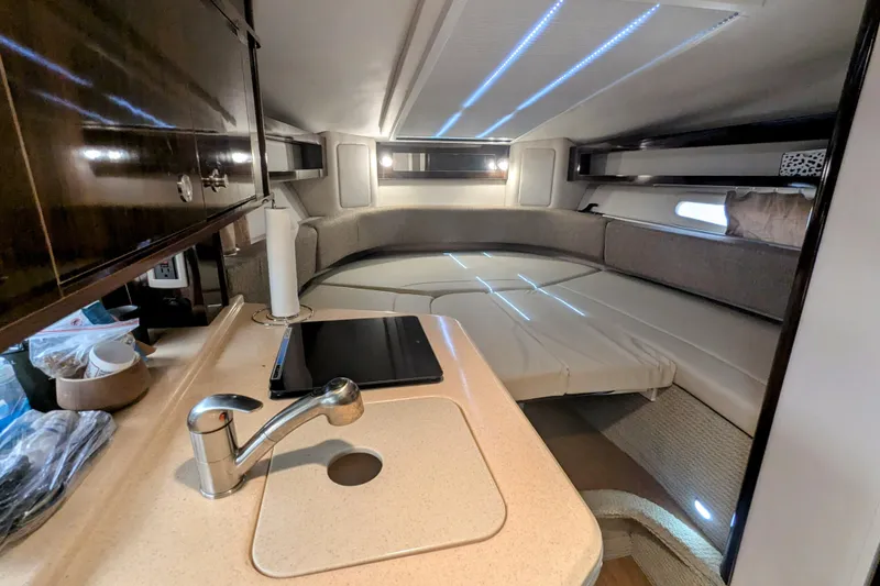 Slide: The Image of Interior of 2017 Sea Ray Sundancer 280, featuring a cozy cabin with kitchenette and seating area. - 22