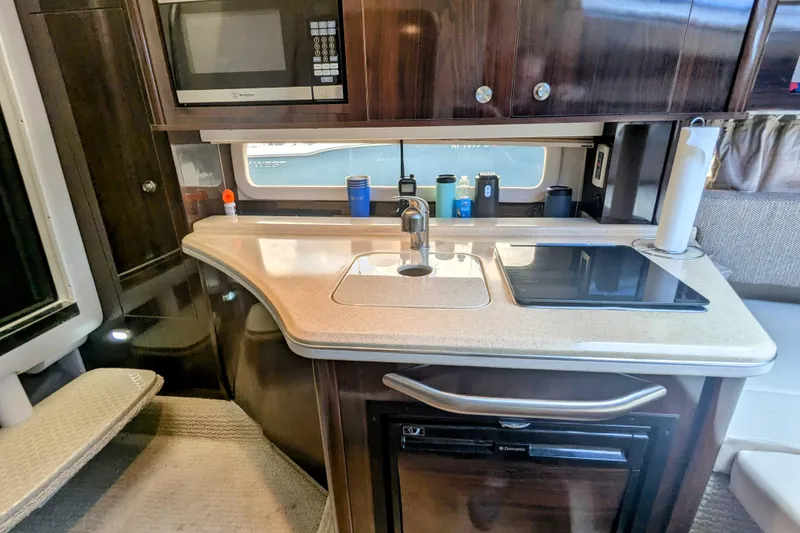 Slide: The Image of 2017 Sea Ray Sundancer 280 galley with microwave, sink, and stovetop. - 23