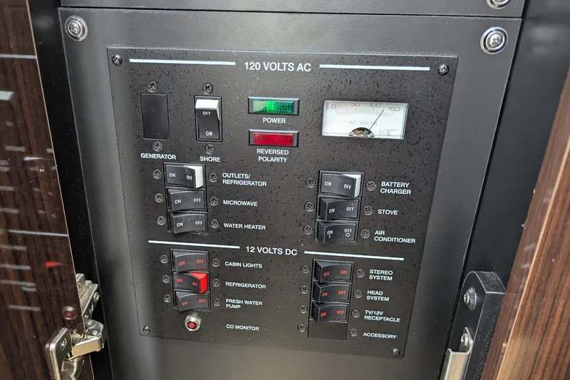 Slide: The Image of Electrical control panel on a 2017 Sea Ray Sundancer 280 boat, showing AC and DC switches. - 31
