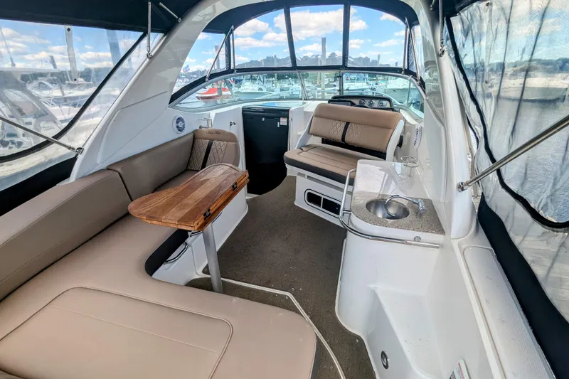 Slide: The Image of 2017 Sea Ray Sundancer 280 interior with seating, table, and sink, docked at marina. - 6
