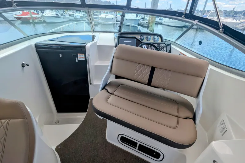 Slide: The Image of 2017 Sea Ray Sundancer 280 interior with helm, seating, and marina view. - 7