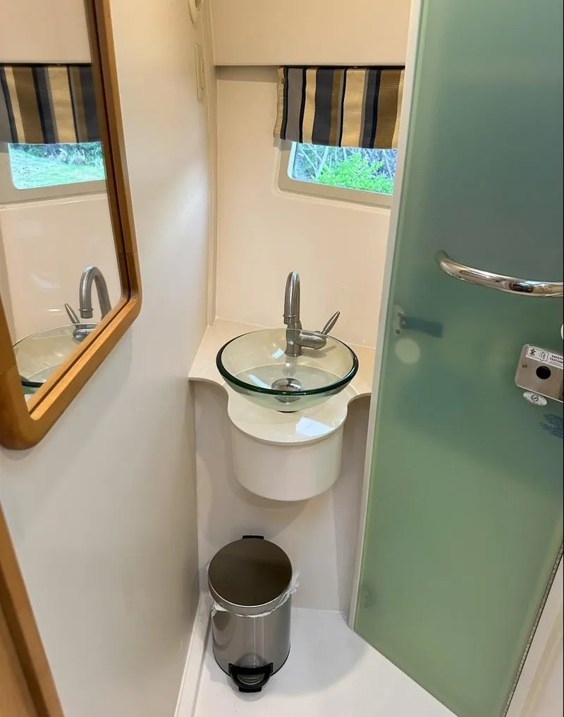 Slide: The Image of Compact bathroom in 2013 Pursuit 365i Sport Coupe with glass sink and modern fixtures. - 10