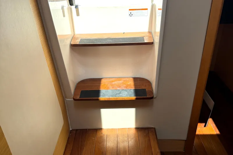 Slide: The Image of Interior wooden steps of a 2013 Pursuit 365i Sport Coupe yacht, illuminated by sunlight. - 12