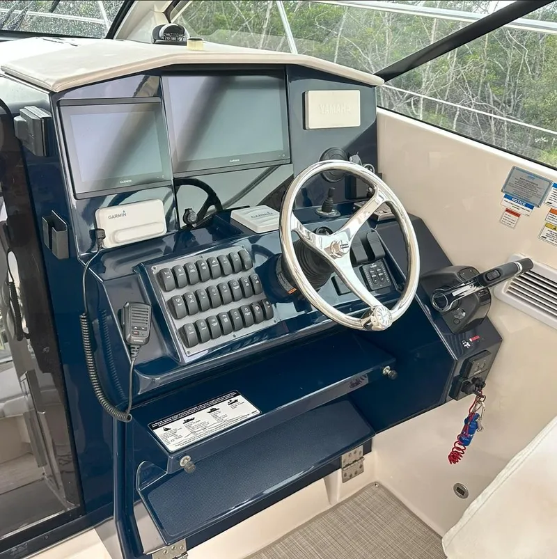 Slide: The Image of Control panel of a 2013 Pursuit 365i Sport Coupe with steering wheel and navigation screens. - 13