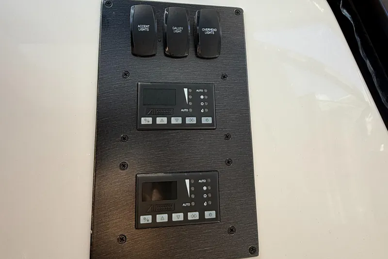 Slide: The Image of Control panel of a 2013 Pursuit 365i Sport Coupe with light switches and digital displays. - 17