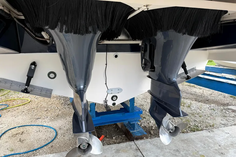 Slide: The Image of 2013 Pursuit 365i Sport Coupe boat with dual outboard motors on a stand. - 27