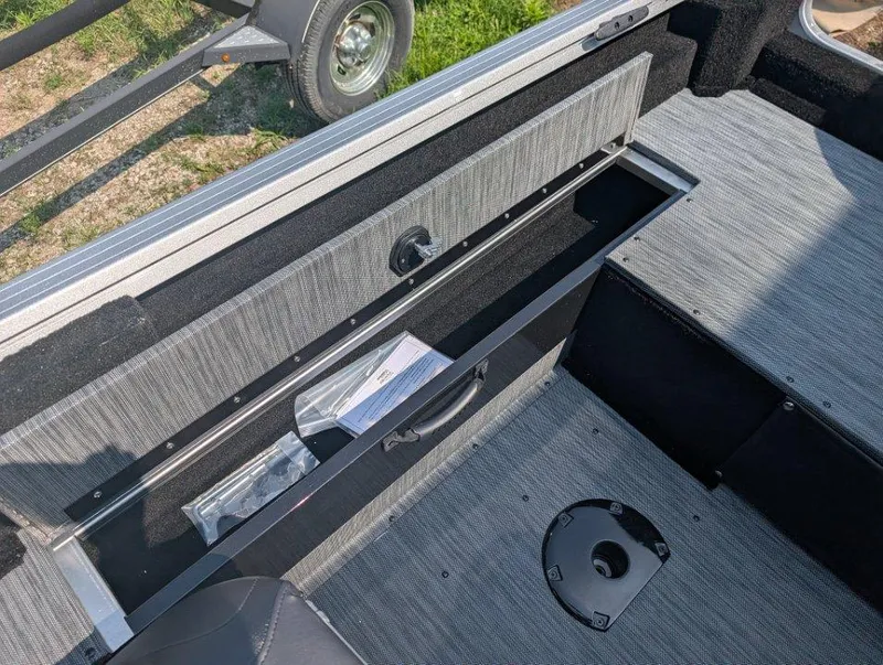 Slide: The Image of 2026 Starcraft 166 Starfish boat interior with open storage compartment and gray flooring. - 10