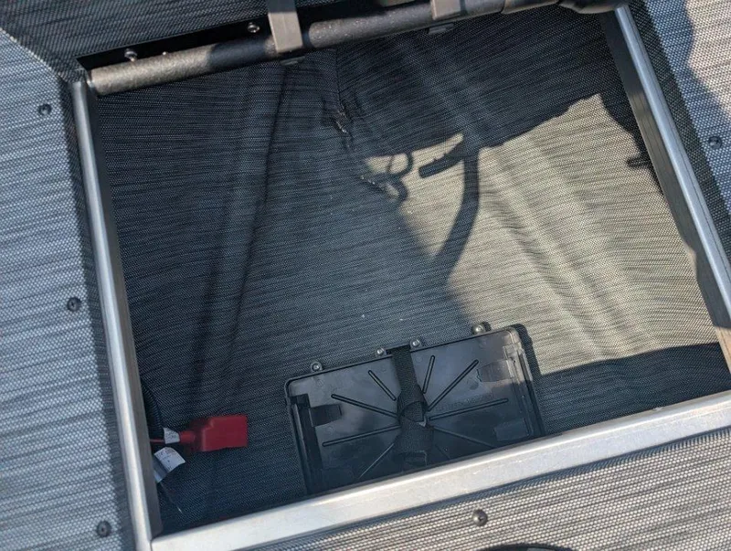 Slide: The Image of Open storage compartment in 2026 Starcraft 166 Starfish boat, featuring a secured battery. - 7