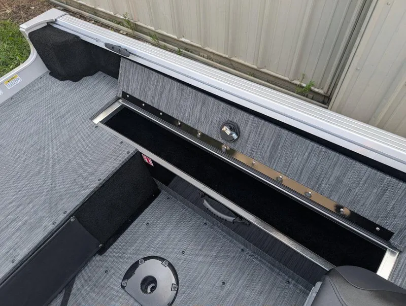 Slide: The Image of 2026 Starcraft 166 Starfish boat interior with storage compartment and gray upholstery. - 9