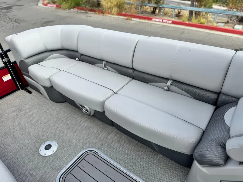 Slide: The Image of 2023 Regency 250 DL3 pontoon boat with spacious gray seating and carpeted flooring. - 11