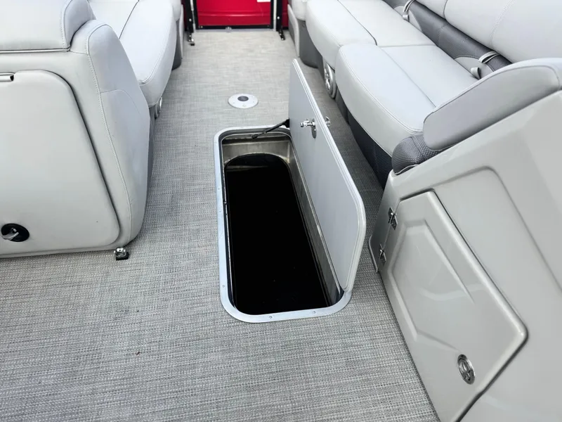 Slide: The Image of 2023 Regency 250 DL3 boat interior with open storage compartment and gray seating. - 12