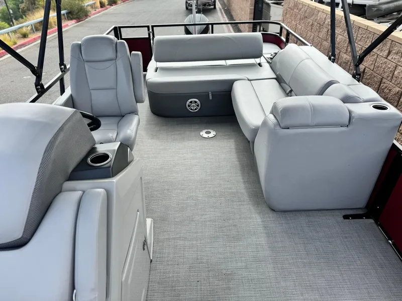 Slide: The Image of 2023 Regency 250 DL3 pontoon boat interior with gray seating and carpet flooring. - 13
