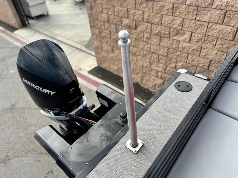 Slide: The Image of 2023 Regency 250 DL3 boat with Mercury outboard motor, docked near brick wall. - 20