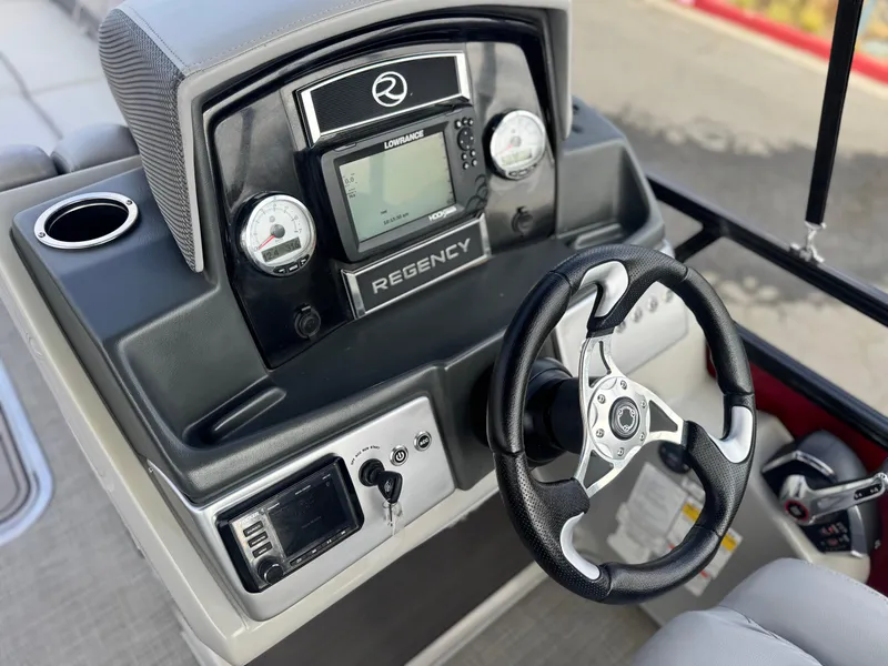 Slide: The Image of 2023 Regency 250 DL3 boat dashboard with steering wheel and control panel. - 23