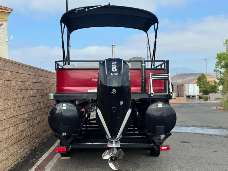 Slide: The Image of 2023 Regency 250 DL3 pontoon boat with V8 engine, parked outdoors. - 5