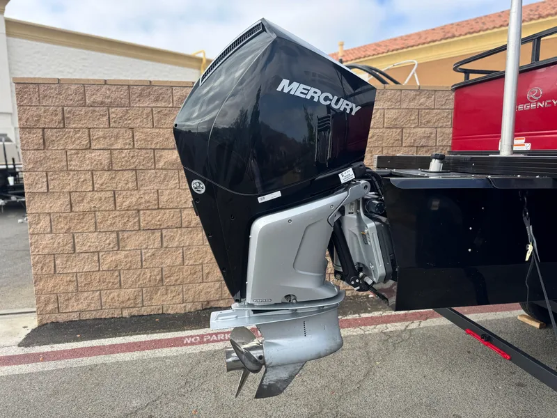 Slide: The Image of 2023 Regency 250 DL3 boat with Mercury outboard motor, parked by a brick wall. - 7