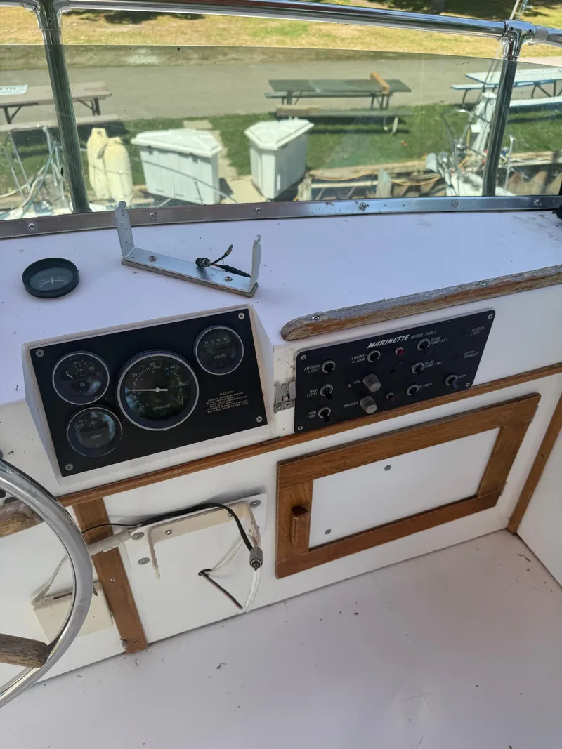 Slide: The Image of 1985 Marinette 32 Sedan dashboard with gauges and controls, featuring wood trim. - 15