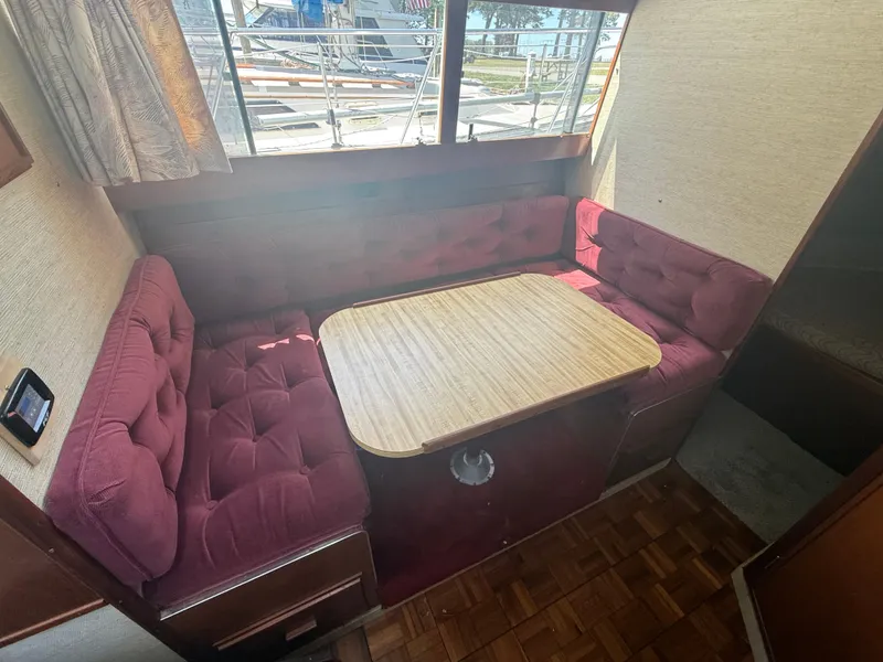 Slide: The Image of Interior of 1985 Marinette 32 Sedan with burgundy seating and wooden table. - 21