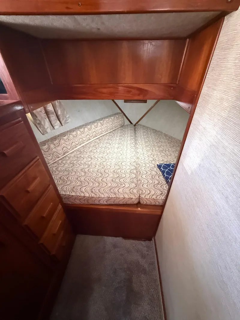 Slide: The Image of Interior cabin of 1985 Marinette 32 Sedan with wood finish and patterned bedding. - 23